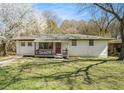 Charming brick home with a cozy front porch, set amidst a lush green lawn and mature trees at 304 Mercer Dr, Jonesboro, GA 30236