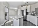Modern kitchen features stainless steel appliances, white cabinets and a light countertop island with seating at 898 Oak Sw St # 1306, Atlanta, GA 30310