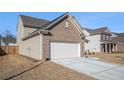 Side view of a home showcasing a two-car garage and well-maintained lawn at 1593 Maston Rd, Auburn, GA 30011