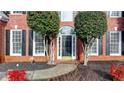 A close up shot of a front door with black shutters and red bushes at 3723 Mossbrook Ter, Suwanee, GA 30024