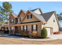 Lovely two-story home featuring a side-entry garage, brick accents, and mature landscaping at 4220 Lindsey Way, Conyers, GA 30013