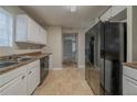 An open kitchen with stainless steel sink, dishwasher, large fridge and tile flooring at 6112 Shadow Rock Ln, Lithonia, GA 30058