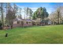 Ranch-style home boasts a well-manicured lawn and mature trees, blending comfort with outdoor beauty at 4183 Hideaway Dr, Tucker, GA 30084