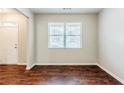 Hardwood floors, white walls, bright window, and white trim create an inviting living room at 450 Lake Ridge Ln, Fairburn, GA 30213