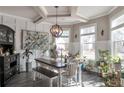 Bright dining room with tray ceilings, modern chandelier, and plenty of natural light from large windows at 531 Eagles Nest Cir, Auburn, GA 30011