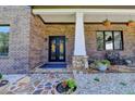 Welcoming front porch with stone accents, wrought iron double doors, and decorative landscaping at 783 Blackberry Trl, Lawrenceville, GA 30043
