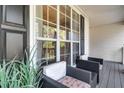 Relaxing front porch with wicker chairs, throw pillows, and a view through large windows at 245 Bartlett Dr, Sharpsburg, GA 30277