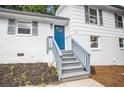 Close up shot of a freshly landscaped yard with a blue door at the front entrance and gray stairs at 6539 Hayes Dr, Riverdale, GA 30274