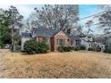 View of a charming brick home with mature landscaping and well-maintained lawn at 1579 Mayflower Sw Ave, Atlanta, GA 30311