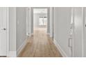 Hallway with hardwood floors and neutral walls leading into a room with a large window at 408 Vinca Nw Cir, Kennesaw, GA 30144