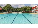 Long swimming pool with lounge chairs, umbrellas, and a large building in the background at 651 Egrets Landing #53, Covington, GA 30014