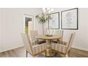 Cozy dining area with a round table, four chairs, elegant decor, and natural light from the doorway at 537 Tuskegee St # 48, Mcdonough, GA 30252