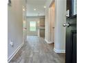 Inviting entryway featuring wood-look floors leading to the kitchen with modern pendant lighting at 642 Egrets Landing #66, Covington, GA 30014