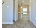 Bright hallway with wood-look flooring leading to a kitchen with stainless steel appliances at 642 Egrets Landing #66, Covington, GA 30014