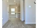 Open concept living area with wood-look floors, a window, and neutral paint at 642 Egrets Landing #66, Covington, GA 30014