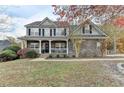 Charming two-story home with stone accents, a welcoming front porch, and landscaped front yard at 1229 Woodmere Dr, Loganville, GA 30052