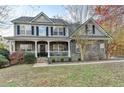 Charming two-story home with stone accents, a welcoming front porch, and landscaped front yard at 1229 Woodmere Dr, Loganville, GA 30052