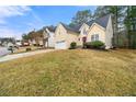 Two-story home featuring a two-car garage, a red front door, and a well-manicured lawn at 11853 Harbour Town Pkwy, Fayetteville, GA 30215