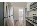 Well-lit kitchen with stainless steel refrigerator and granite countertops adjacent to living area at 1433 Dennis Dr, Decatur, GA 30032