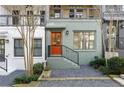 Attractive townhome exterior with a brightly colored front door, landscaped yard, and wrought iron railing at 754 Aerial Way, Atlanta, GA 30312