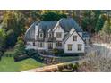 Beautiful two-story home with manicured landscaping, stone accents, and a welcoming front porch at 135 Newcastle Ct, Roswell, GA 30076