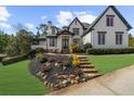Inviting two-story home with well-maintained lawn, stone pathway, and charming front entrance at 135 Newcastle Ct, Roswell, GA 30076