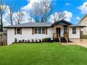Charming home featuring a brick facade, covered entry, and well-manicured lawn at 2308 Mark Trl, Decatur, GA 30032