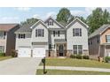 Inviting two-story house with a lush green lawn, a double garage, and dark window shutters at 4416 Water Mill Dr, Buford, GA 30519