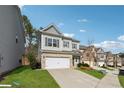 View of home with lawn and driveway with gray siding and brick two car garage at 103 Bryon Ln, Acworth, GA 30102
