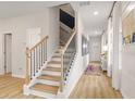 Inviting staircase with wooden steps, black railing, and a view of the entrance at 204 Sanctuary Dr, Mcdonough, GA 30253