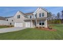 Charming new two-story home featuring a three-car garage, gray brick and siding, and a well-manicured lawn at 112 Felicity Pike, Locust Grove, GA 30248