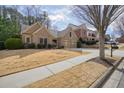 Lovely brick home with a two-car garage, a spacious driveway, and mature trees surrounding the property at 620 Willow Haven Way, Suwanee, GA 30024