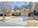 Inviting brick home with attached two-car garage, long driveway, and manicured front lawn at 620 Willow Haven Way, Suwanee, GA 30024