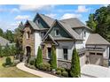 Stylish two-story home with lush landscaping around the home and a two car garage on the side at 3111 Old Thompson Mill Rd, Buford, GA 30519