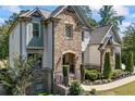 Charming two-story home featuring a combination of stone and siding, complemented by mature landscaping at 3111 Old Thompson Mill Rd, Buford, GA 30519
