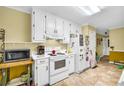 Functional kitchen showcasing white appliances, ample cabinetry, and durable tile flooring at 3434 Saddlebrook Dr, Loganville, GA 30052