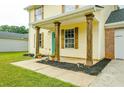 Inviting front porch with wooden columns, a teal door, and tasteful landscaping at 5484 Denny Dr, Atlanta, GA 30349