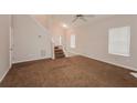 Spacious living room featuring vaulted ceilings, carpeted floors and a staircase to the upper level at 6595 Browns Mill Ferry Dr, Lithonia, GA 30038