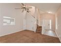 Bright living room features high ceilings, wood and carpeted floors, and a staircase to the upper level at 6595 Browns Mill Ferry Dr, Lithonia, GA 30038