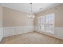 A neutrally decorated room with crown molding, plantation shutters and a crystal chandelier at 923 Port West Dr, Auburn, GA 30011