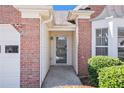 Close-up of the home's front door framed by brick, enhanced with manicured shrubs at 2794 Hillvale Cove Way, Lithonia, GA 30058