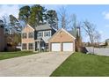 Traditional two-story home with a brick and siding facade, a two-car garage, and green front lawn at 3185 Perch Sw Dr, Marietta, GA 30008