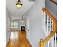 Bright hallway with hardwood floors leads to a living area with a fireplace and staircase at 1649 Southgate Mill Dr, Duluth, GA 30096