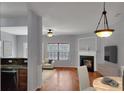 Bright living room featuring a fireplace, hardwood floors, and a dining area at 1649 Southgate Mill Dr, Duluth, GA 30096