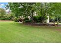 Spacious front yard with lush green lawn, mature trees, and well-maintained landscaping at 1850 Kirkmont Nw Dr, Marietta, GA 30064