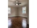Cozy bedroom featuring hardwood flooring, two windows, neutral paint and white trim at 197 Upshaw Sw St, Atlanta, GA 30315