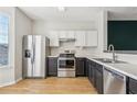 Modern kitchen with stainless steel appliances, contrasting dark and white cabinets, and wood-look flooring at 103 Timber Ridge Dr, Cartersville, GA 30121