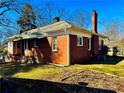 A brick home with a chimney and an unfinished yard at 1948 Mercer Ave, College Park, GA 30337