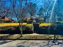 View of brick home and front yard from the street showing the landscaped lawn and trees at 1948 Mercer Ave, College Park, GA 30337