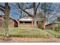 Charming brick home with a covered front porch, mature trees, and landscaping at 1523 Melrose Sw Dr, Atlanta, GA 30310